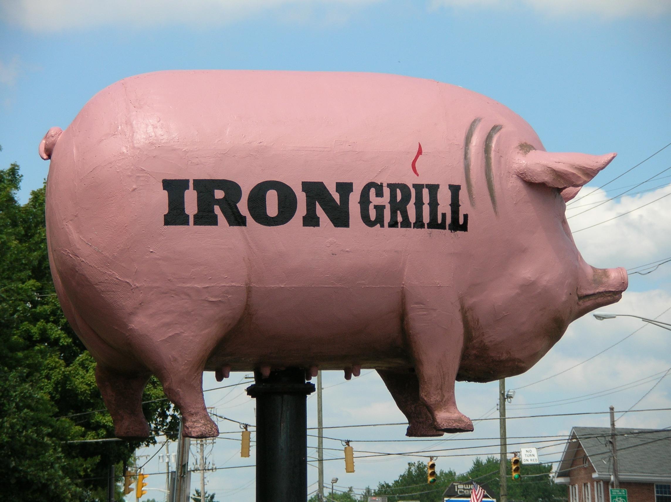 Side View of the Pig Sign in Front of Iron Grill Barbeque & Brew