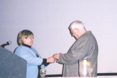 Photograph of Sally Oddi Giving the Jo Osborne Award to Tomie dePaola