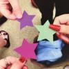 Three hands holding cut out stars