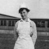 Harriet Elizabeth Putman Standing in Field in Front of Building