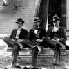 Three men sitting on a bench in front of the Worthington Presbyterian Church ca 1880-1900)